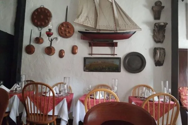 Dining room with copper cookware and model schooner